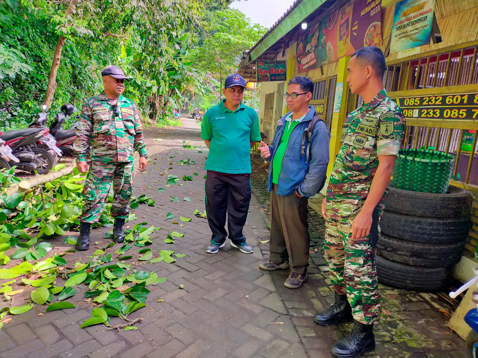 Camat Klakah membantu  dalam evakuasi  tempat parkir warung yang tertimpa Pohon Tumbang di sekitar  